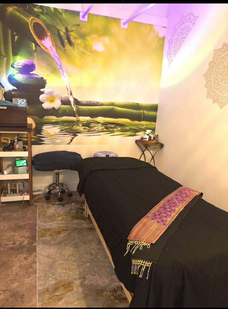 Massage room with a bed and a painting on the wall